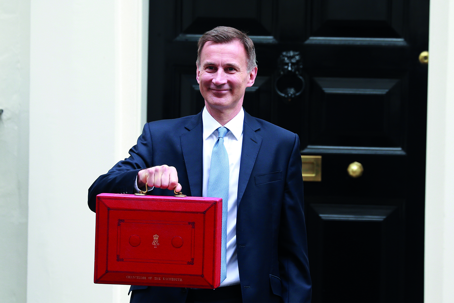 photo of Chancellor Jeremy Hunt holding up red budget bag