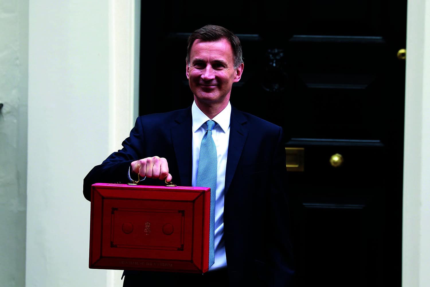 photo of Chancellor Jeremy Hunt holding up red budget bag