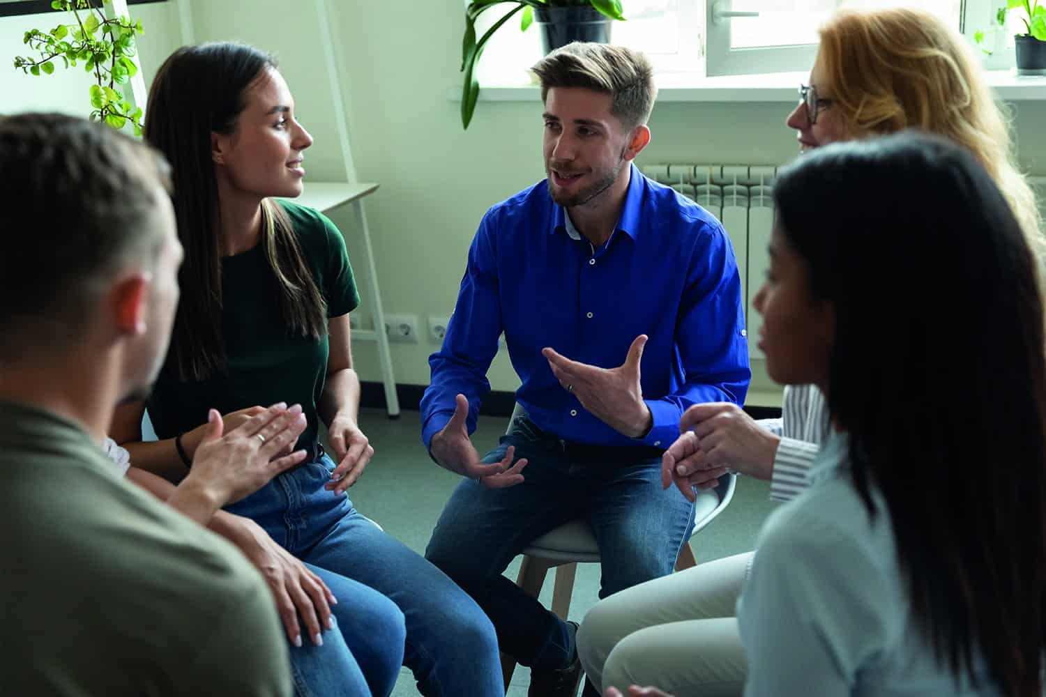 A group of people sitting in a circle having a discussion