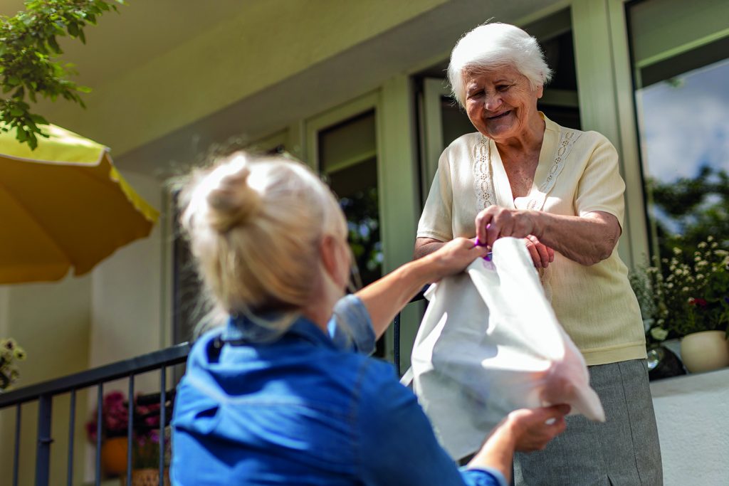 Two old women sharing a bag of products.