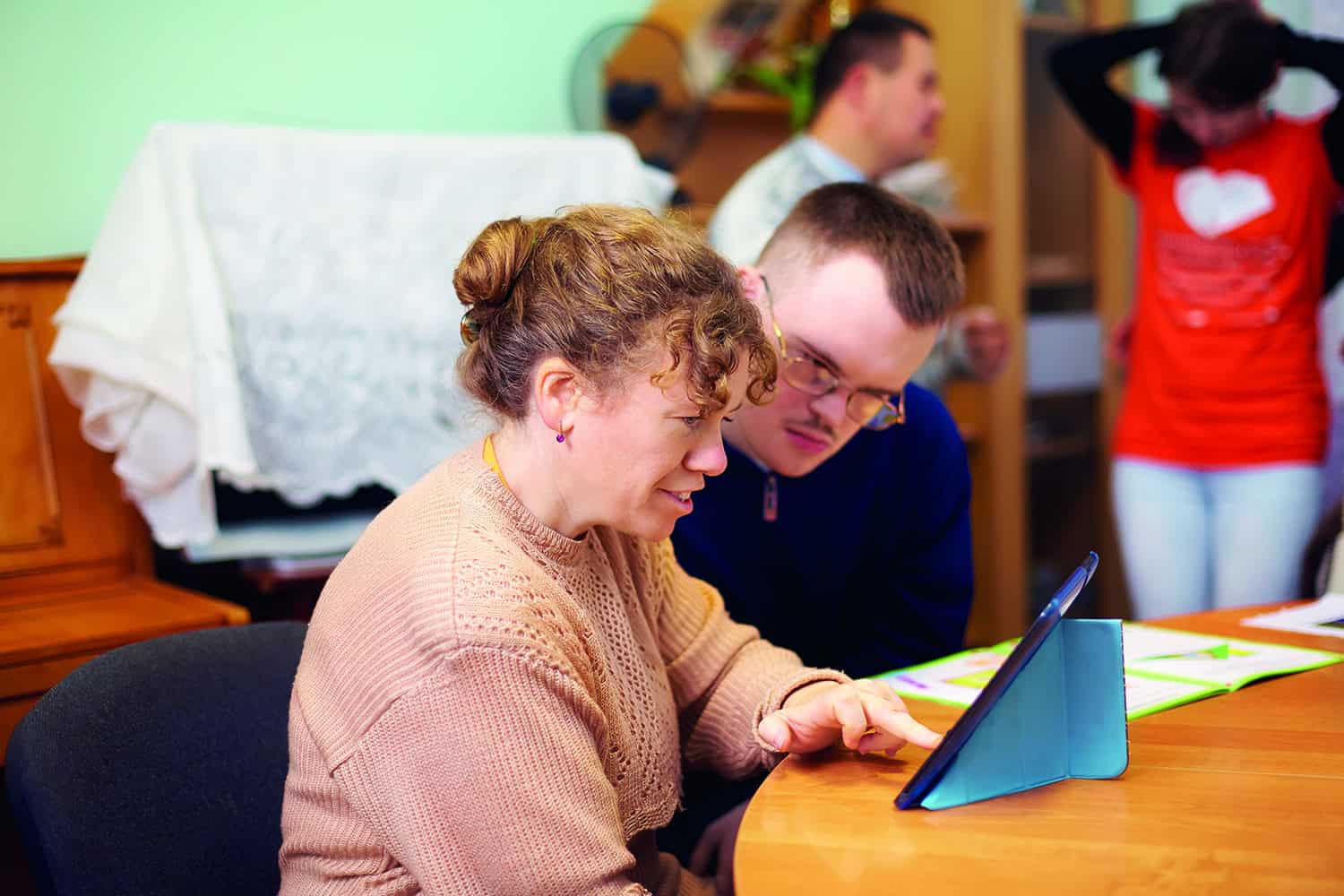 A man and a woman looking at a electronic device