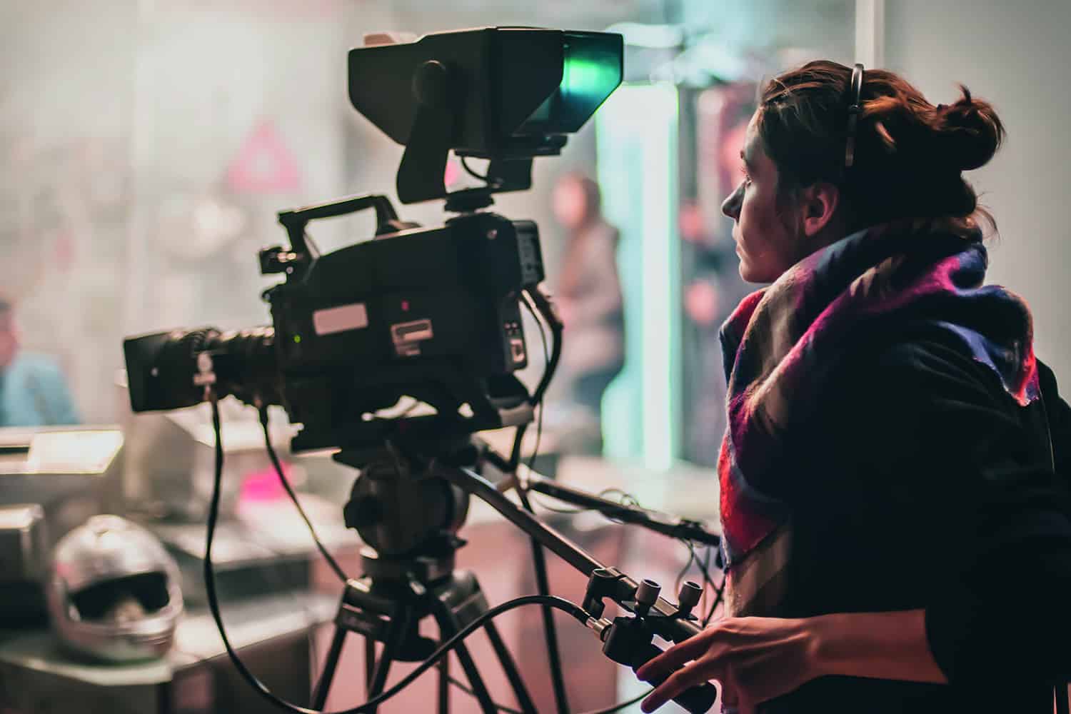 A young woman behind a camera on a film set