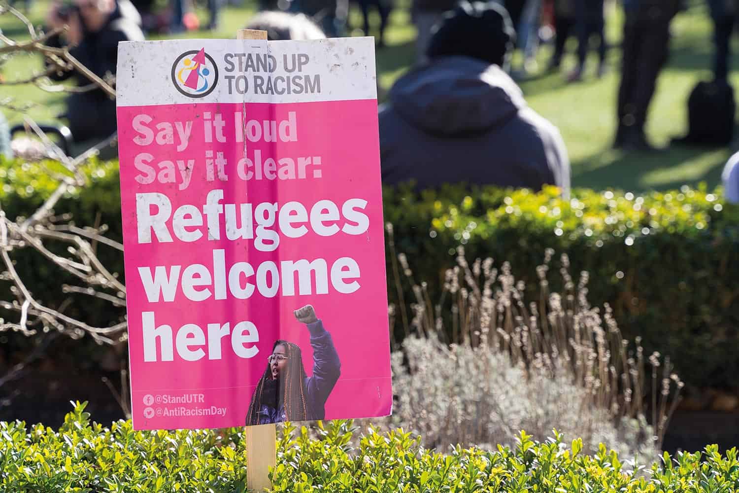 A protest placard that says refugees welcome here.