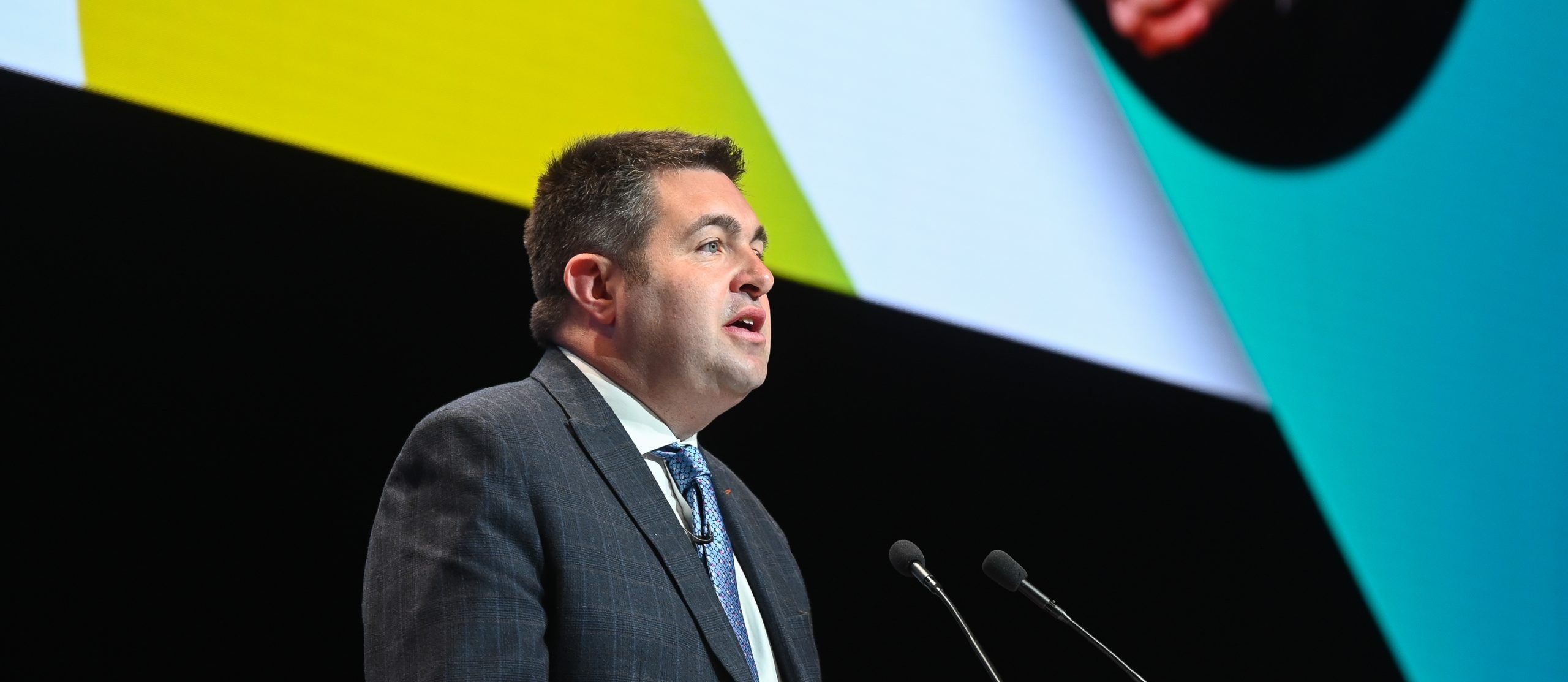 LGA Chair Cllr Shaun Davies at a lectern in a conference hall giving a speech