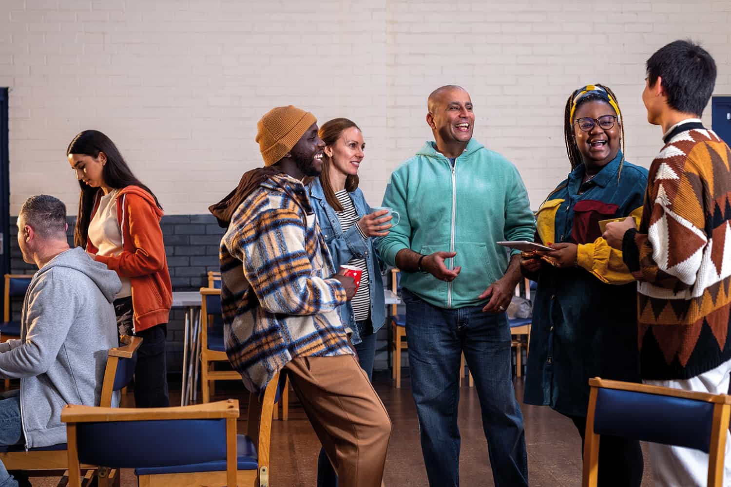 A group of people at a social meet up having a conversation and smiling