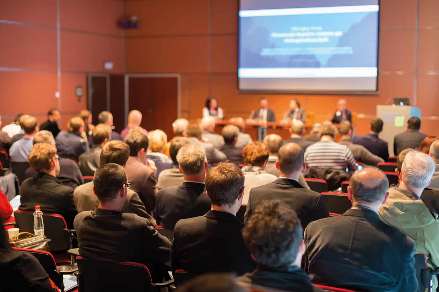 A group of people listening to a panel at an event