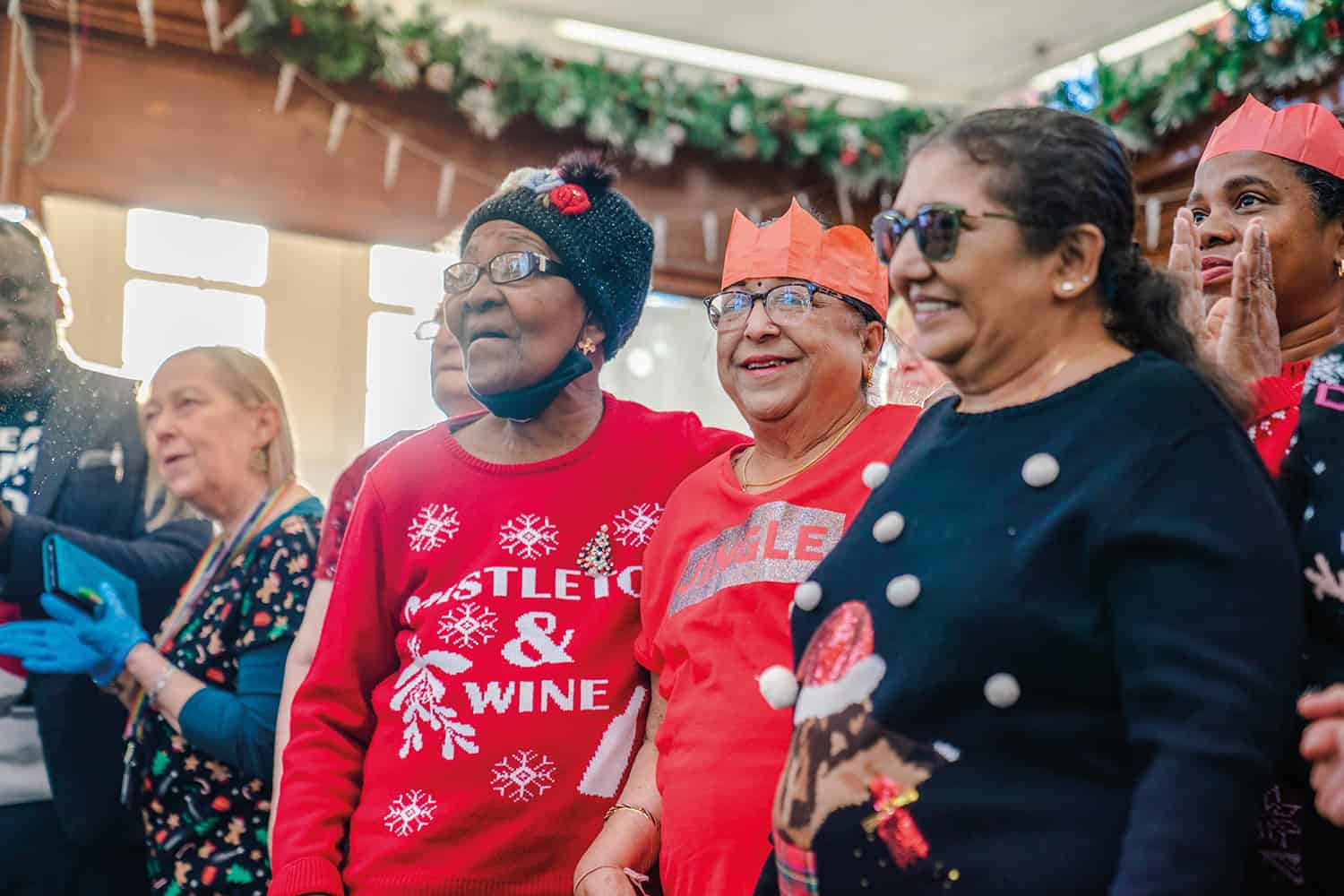 photo of group of older women in Christmas hats and jumpers at The Big Lunch at Christmas, London Borough of Newham 2022