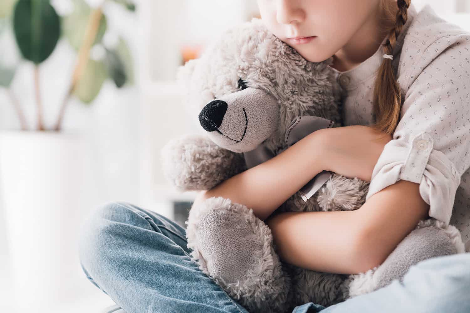 young girl cuddling teddy bear