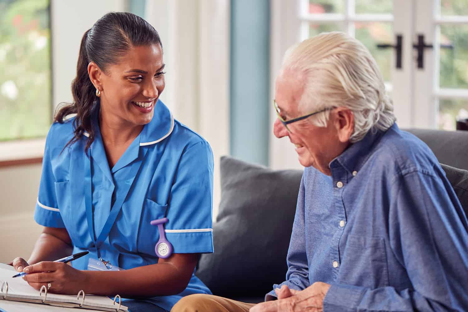 smiling female care worker with older man