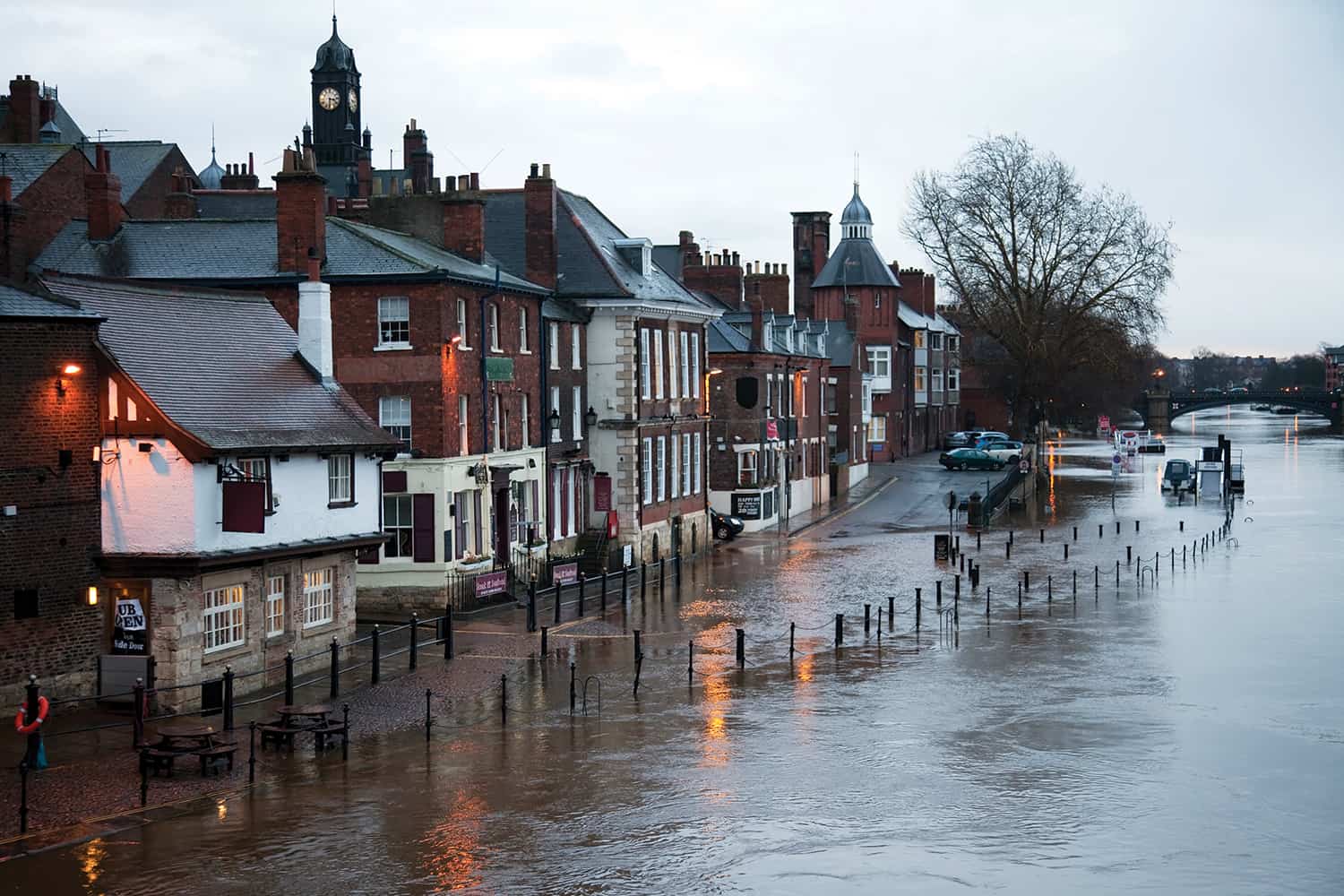 A river bursts its banks on a high street.