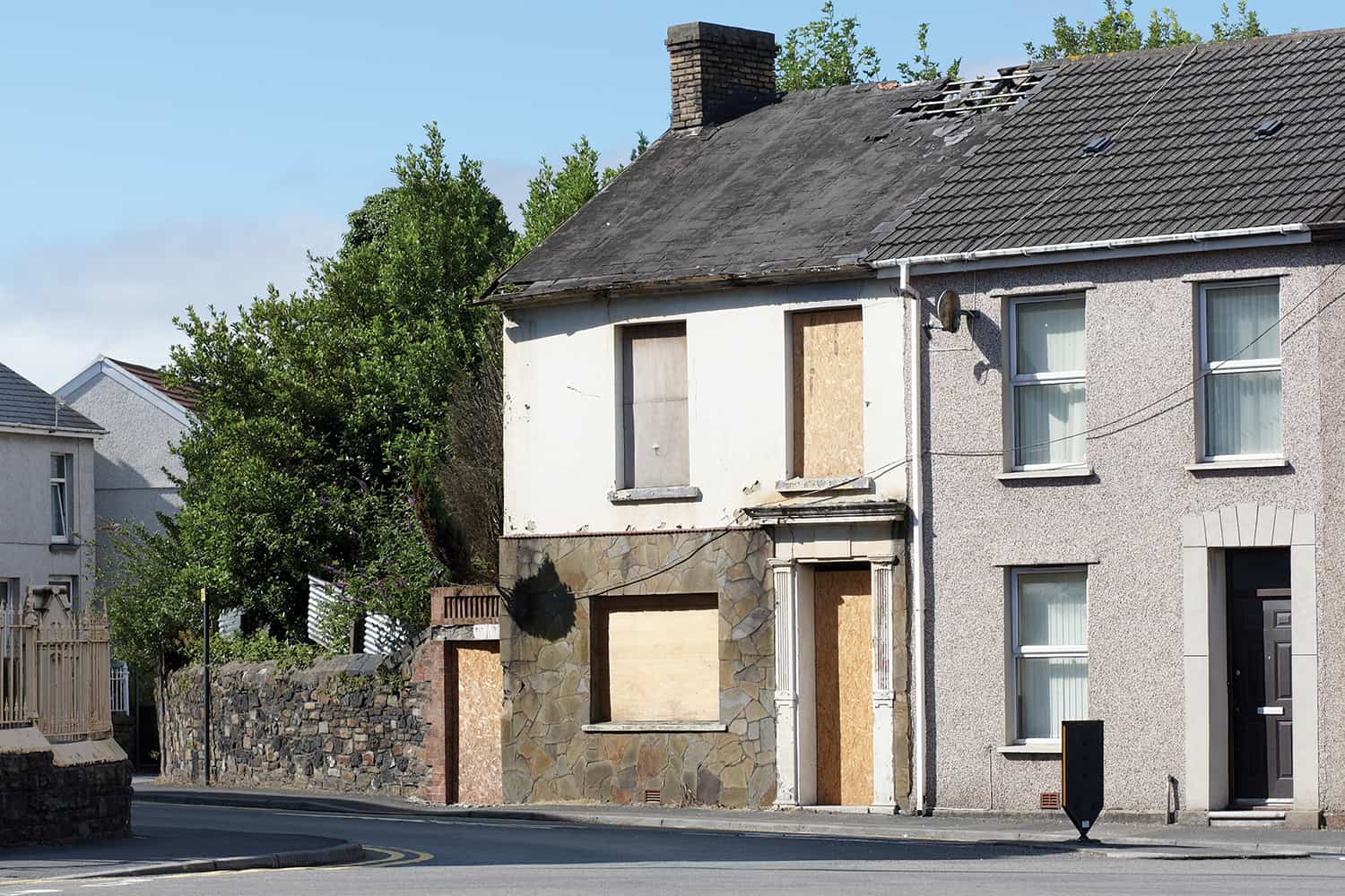 A house with boarded windows and door.