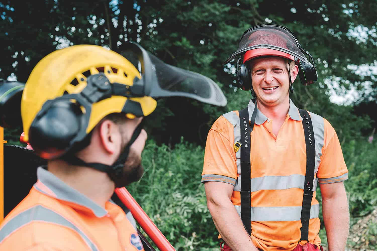 Durham County Council arborists in safety helmets with visors and earguards, outdoors, smiling. Copyright Durham County Council