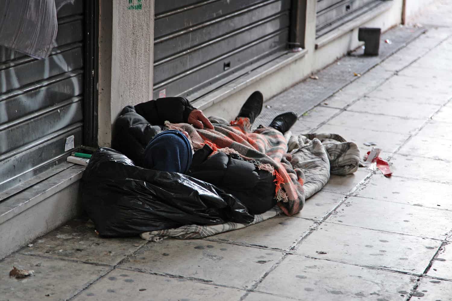 A homeless person lying on the street