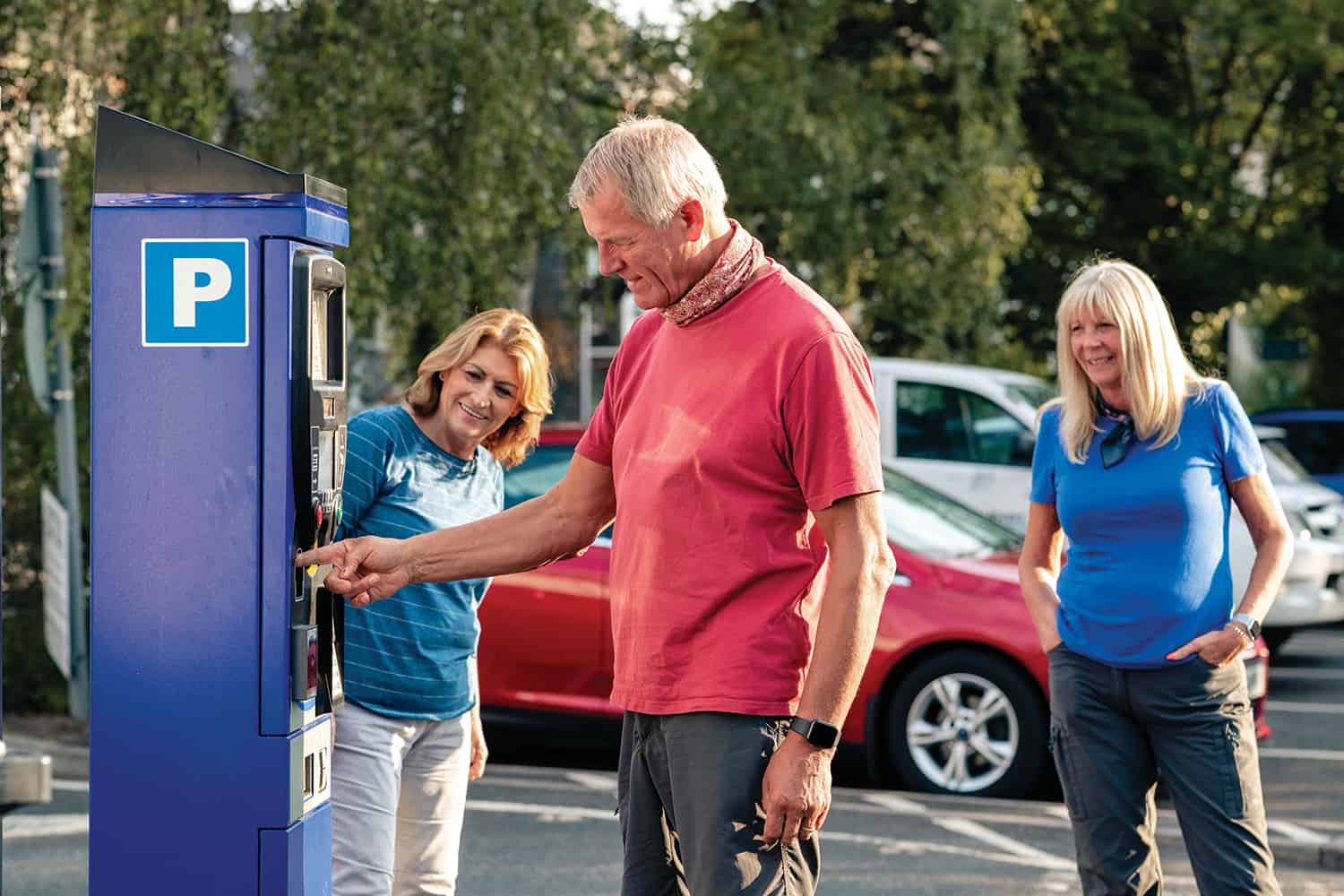 A man with his family using a ticket machine in a car park