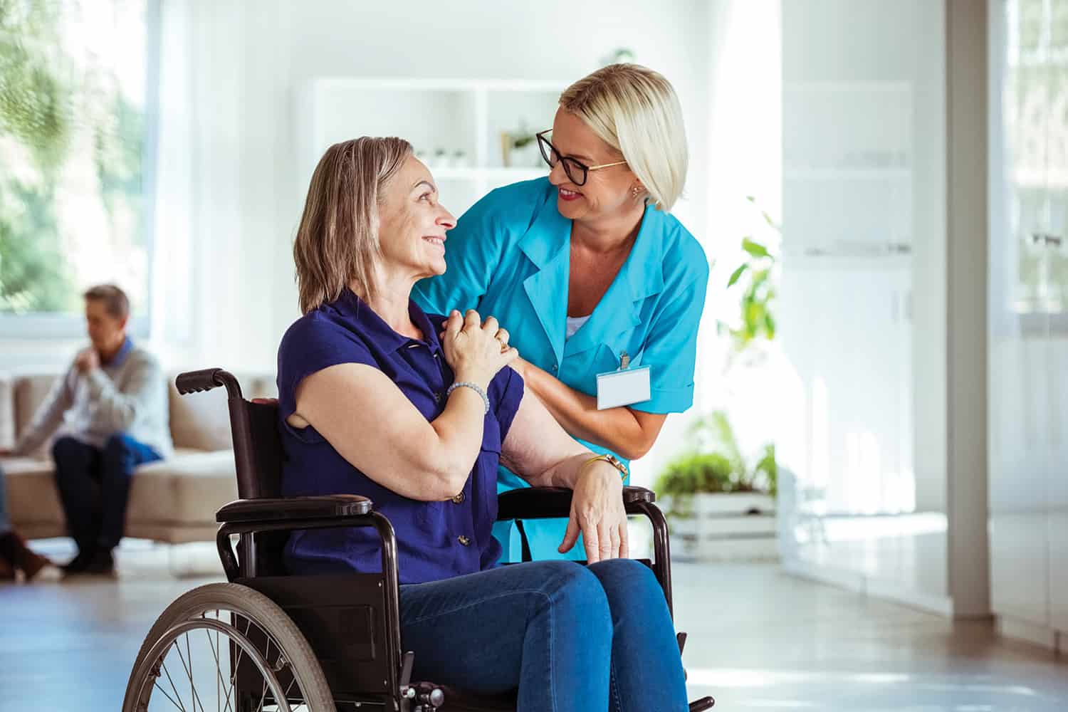 A woman in a wheelchair chatting to a nurse