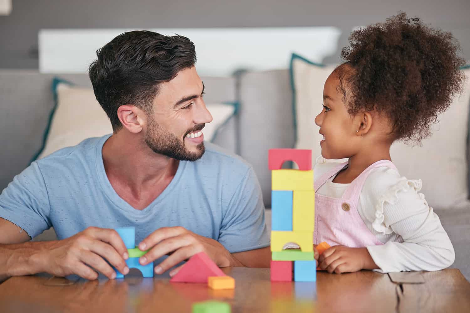 A young girl and an adult supervisor playing with building blocks