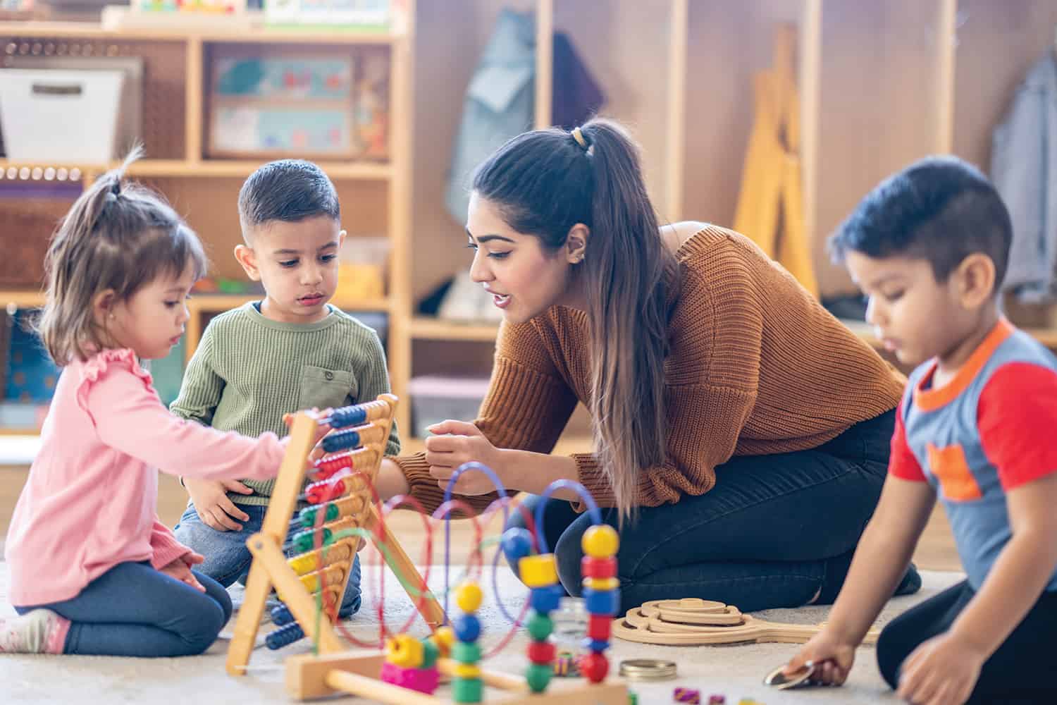 A woman playing with children in a nursery.