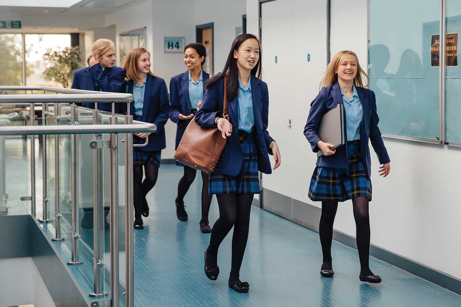 A group of teenage pupils walking down a school corridor
