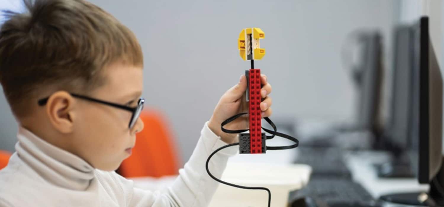 A child with a vision impairment playing with a tool on the computer.