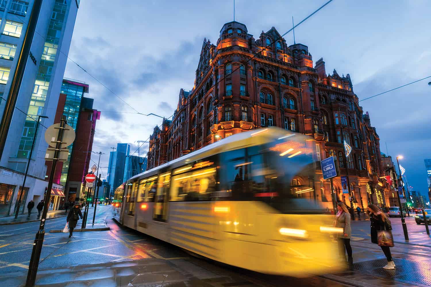 photo of moving, blurred tram in Manchester city centre, evening