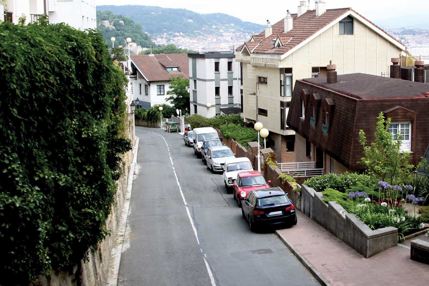 photo looking down on cars parked on pavement on residential street