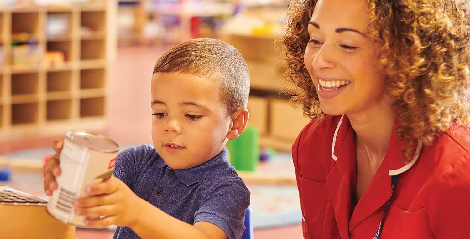 A child playing with a carer in a playing area