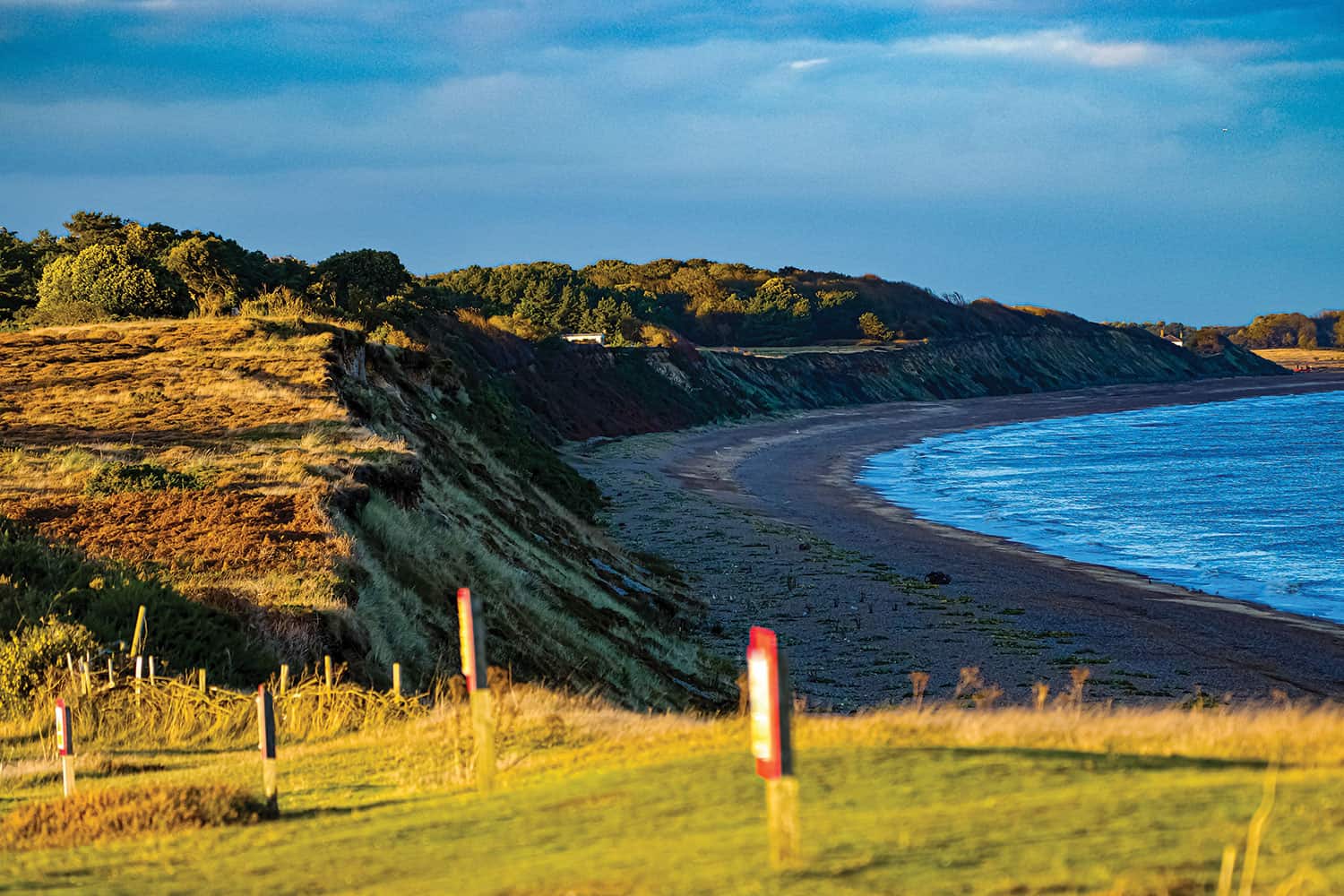 A seaside coast in the UK seen from above some cliffs.