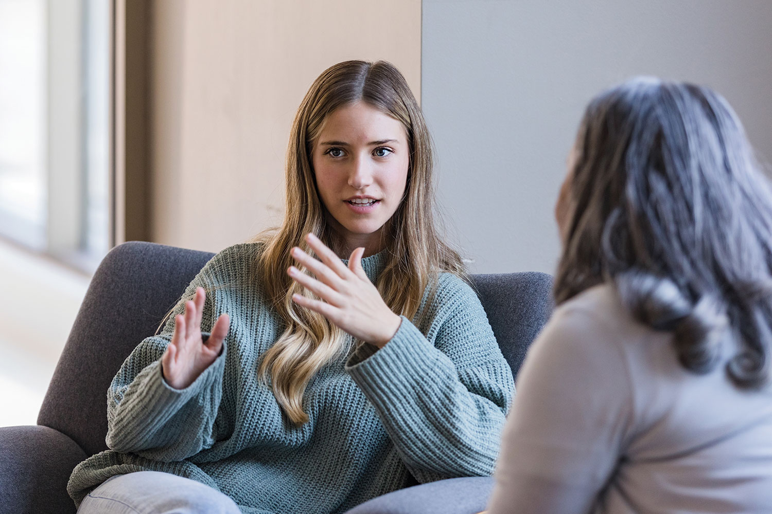photo of young female care leaver talking to social worker on comfy sofa