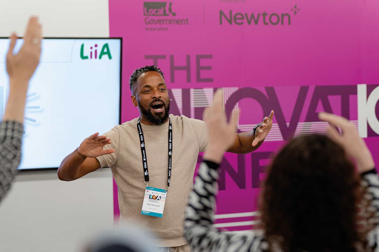 TV presenter and choral coach Mark De-Lisser with delegates with hands in the air in the Innovation Zone at the LGA’s 2024 annual conference