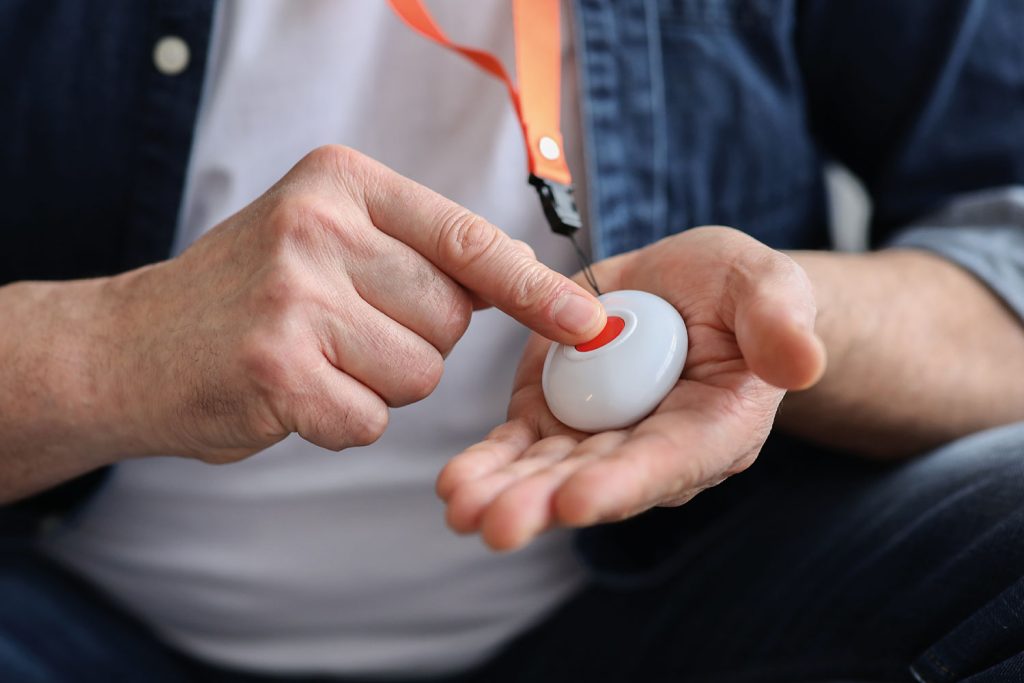 close-up of adult pressing button on telecare pendant