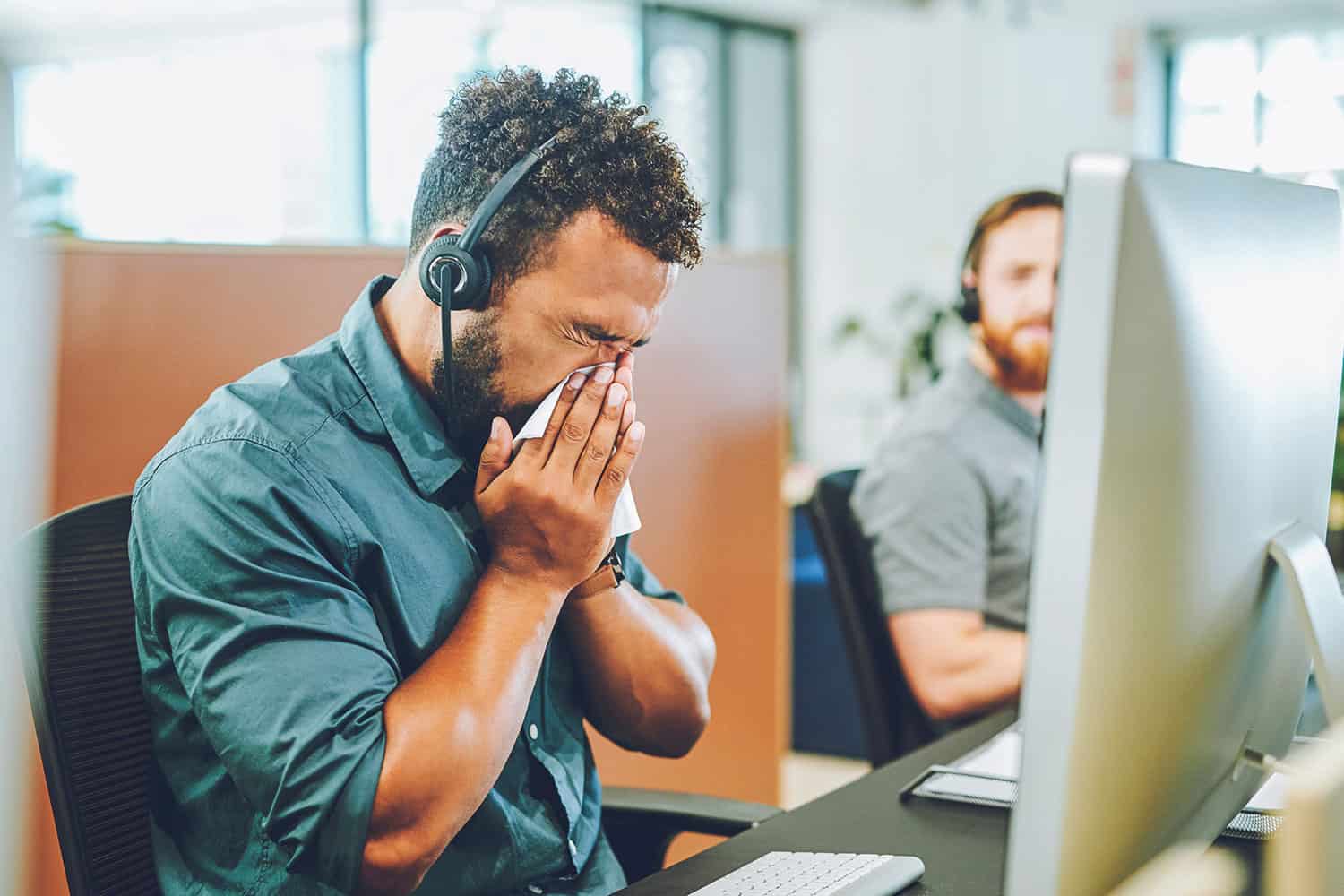 photo of worker in call centre blowing nose