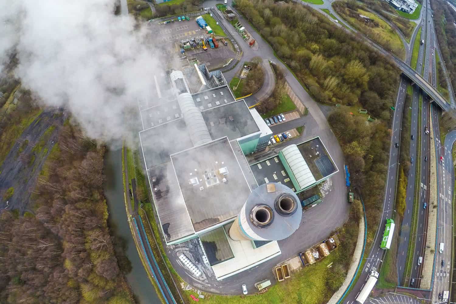 photo from above of smoke issuing from the chimney of a waste incineration plant