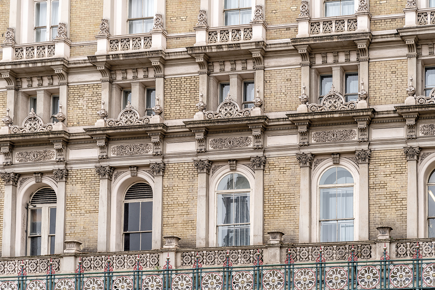 frontage of historic building focusing on decorative but slightly run-down looking windows