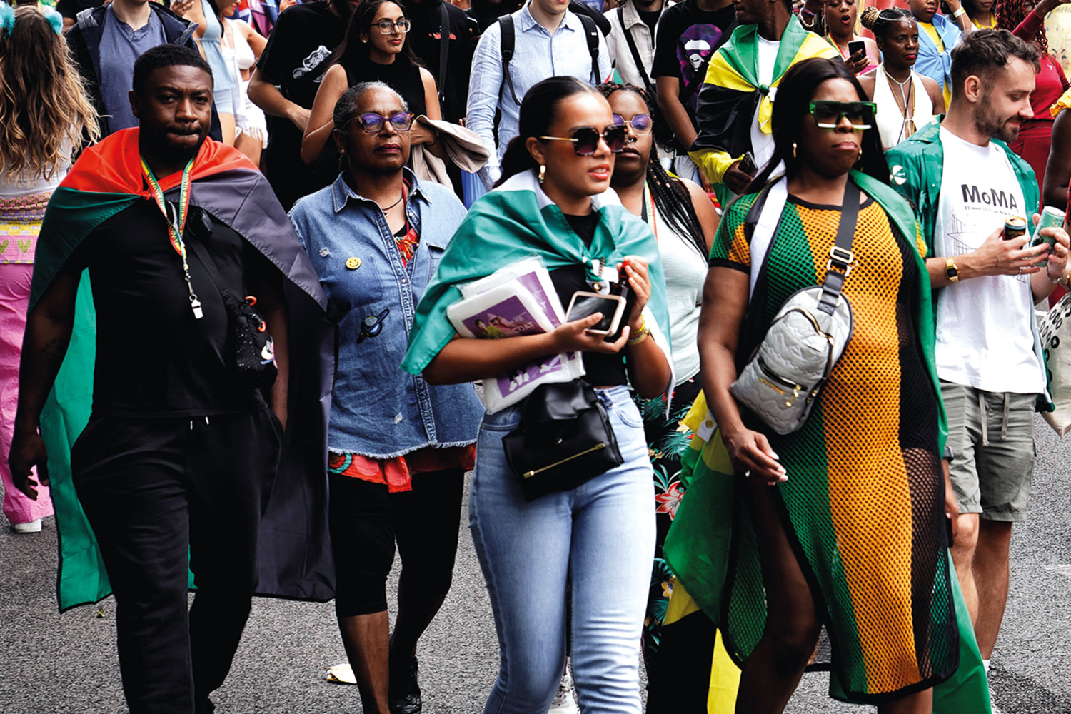 photo of members and supporters of the Windrush community marching down a street
