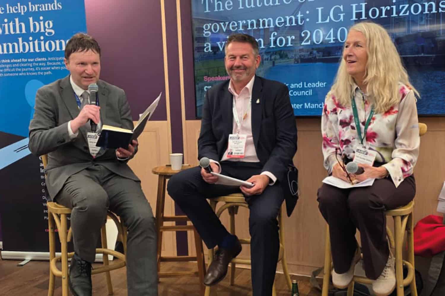 photo of Yorkshire Post’s Greg Wright and the LGA’s Cllr Richard Wright and Cllr Louise Gittins sitting on stools at a session at UKREiiF