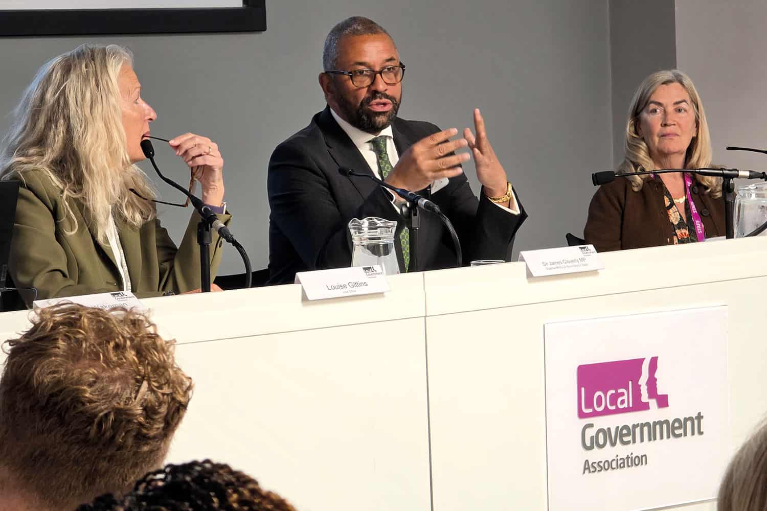 photo of LGA Chair Cllr Louise Gittins looking at Sir James Cleverly MP, Shadow Secretary of State for Housing, Communities and Local Government, speaking at the LGA’s most recent Councillors’ Forum