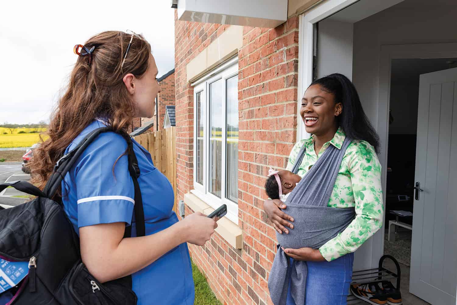 a health carer visiting a mother with a baby