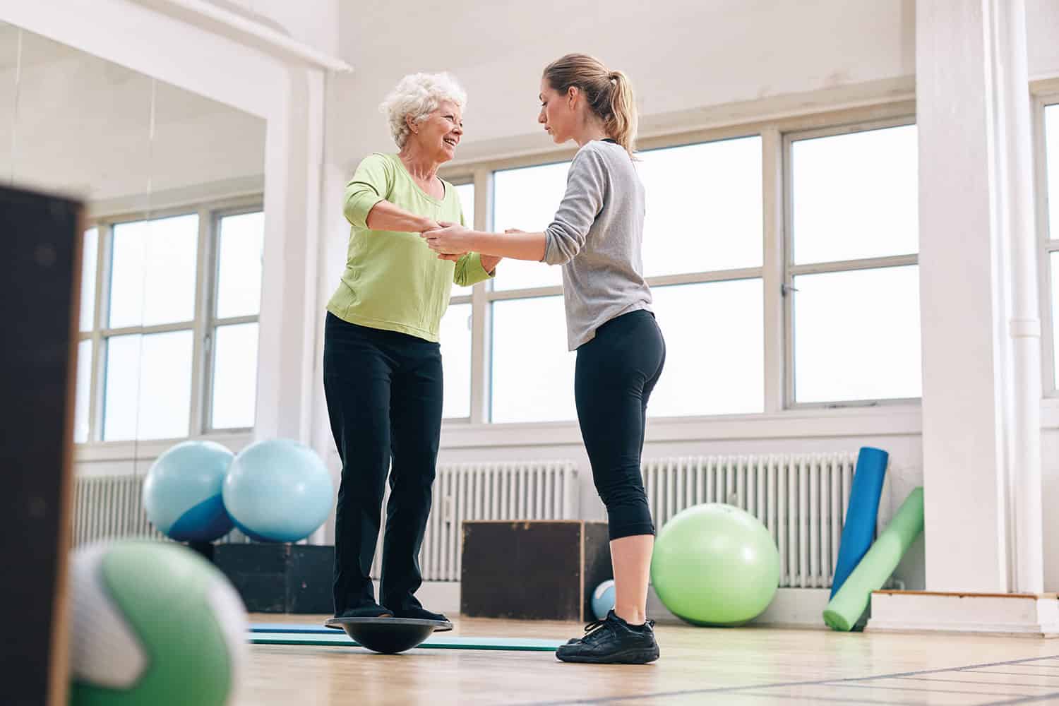 A carer helping an elderly woman to exercise